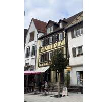 historisches Wohn- und Geschäftshaus in der Tauberbischofsheimer Fußgängerzone mit Parkplatz