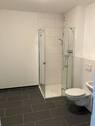 Bad mit Dusche, hellen Wandfliesen und dunklen Bodenfliesen - 2 Zimmer Etagenwohnung zur Miete in Wetzlar