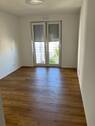 Schlafzimmer mit bodentiefen Fenstern, weißen Wänden und Boden in Holzoptik - 2 Zimmer Etagenwohnung in Wetzlar