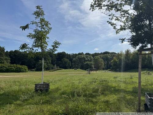Gegenüberleigende Grünanlage mit Spielplatz und Spazierwegen - 