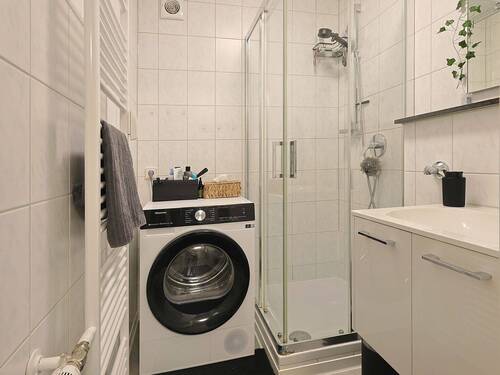 Hell gefliestes Badezimmer mit Duschkabine und Waschmaschinenanschluss - Etagenwohnung mit 66,00 m&sup2; in Leonberg zum Kaufen