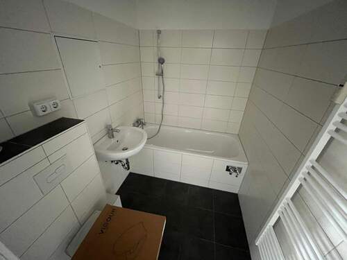 Badezimmer mit Wanne und Handtuchheizkörper - 