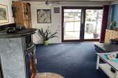 Wohnzimmer mit Kaminofen und Ausgang zur Terrasse - 