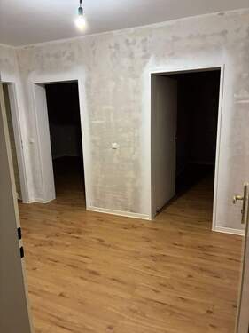 Blick in den Flur. Neuer Vinyl in braun. Wände tapezierfähig. Decken Weiß. - 