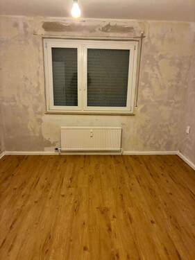 Wonzimmer. Decken weiß gestrichen. Wände tapezierfähig vorbereitet. Neuer brauner Vinylboden. - 