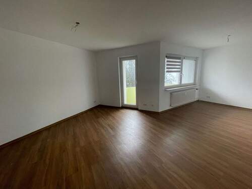 Wohnzimmer mit Zugang zum Balkon, Flurbereich, brauner Laminatfußboden und weiß gestrichene Wände - 3 Zimmer Etagenwohnung in Frankfurt am Main