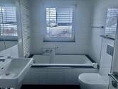 Modernes Badezimmer mit Wanne, Dusche und Fenster - 