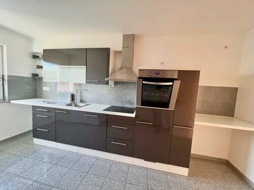 Moderne Küche mit hochwertigen Einbaugeräten und praktischer Arbeitsfläche - 