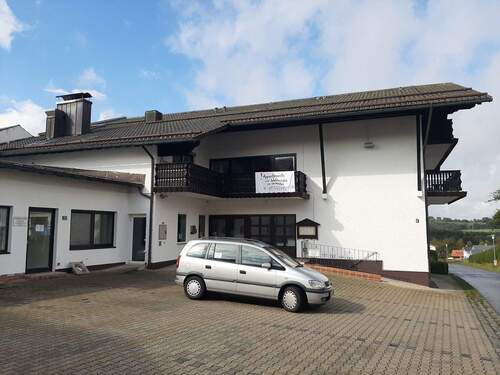 Blick vom Parkplatz aufs Haus - 2 Zimmer Etagenwohnung zur Miete in Frauenau