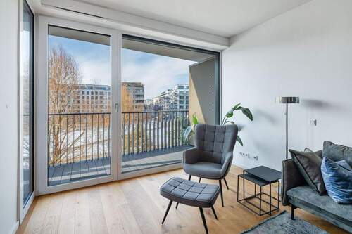 Gemütliche Möbel vor bodentiefen Fenstern - 