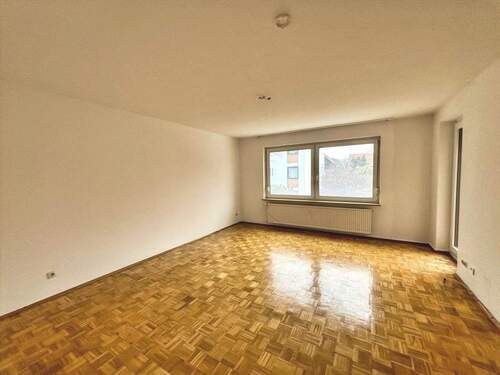 Wohnzimmer mit Parkettfußboden und Zugang zum Balkon - 