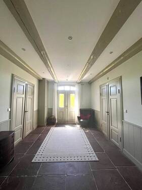 Ein Eingangsbereich mit Steinplatten und Friesentüren bringt den authentischen Charme norddeutscher Architektur in das Anwesen - 