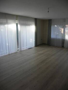 Wohnzimmer mit bodentiefen Fenstern - 