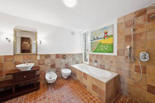 Das Masterbad verströmt mediterranes Flair mit warmen Naturtönen. - 