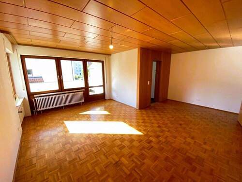 Wohnzimmer mit Blick zum Balkon und Küchenzugang - 