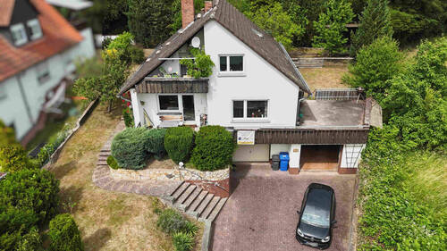 Gebäudefront als Drohnenansicht - Einfamilienhaus mit Einliegerwohnung und zwei Garagen auf großzügigem Grundstück in Goldbach