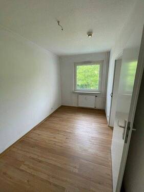 Schlafzimmer mit weißen, tapetenlosen Wänden, einem Deisgn-Vinylboden in Holzoptik und Fenster. - 1 Zimmer Etagenwohnung in Bad Homburg vor der Höhe