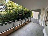 Balkon umgeben von Bäumen und Sträuchern - 
