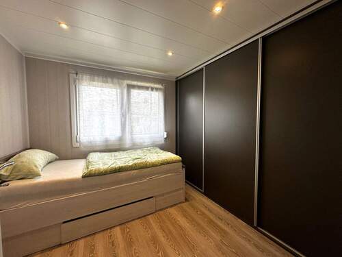 Schlafzimmer mit Einbauschrank und Fenster - 