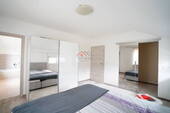 Schlafzimmer mit begehbarem Kleiderschrank sowie Zugang zum Badezimmer - 