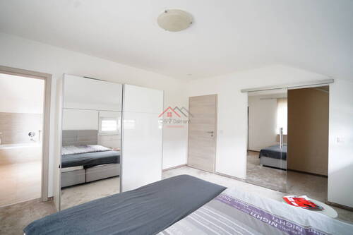 Schlafzimmer mit begehbarem Kleiderschrank sowie Zugang zum Badezimmer - 