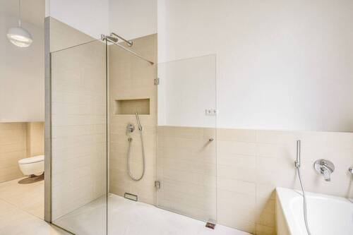 Bad mit ebenerdiger Dusche, Badewanne und Fenster - 