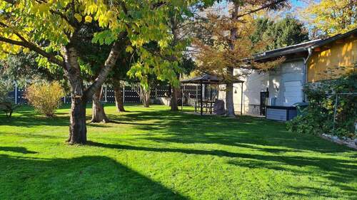 Garten mit Blick auf Sitzgruppe und Rohbau - 