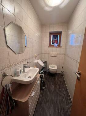 Helles Badezimmer mit praktischem Waschtisch und WC, durchdachte Raumaufteilung - 