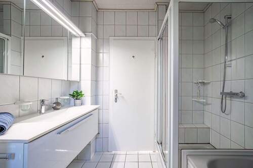 Der Raum ist mit einer Badewanne und einer Dusche ausgestattet. - 