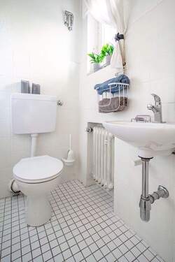 Das hell geflieste Gäste-WC stammt aus dem Baujahr. - 