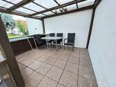 Überdachte Terrasse hinter Garagen - 