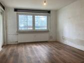 Wohnzimmer mit neuem Fußbodenbelag in Holzoptik, die Wände sind tapezierfertig vorbereitet - 