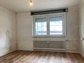Schlafzimmer mit neuem Fußbodenbelag in Holzoptik, die Wände sind tapezierfertig vorbereitet - 