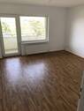 BEISPIELBILD: Wohnzimmer mit PVC-Bodenbelag in Holzoptik und Zugang zur Loggia - 3 Zimmer Etagenwohnung in Bad Nauheim