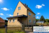 Vorder- und Seitenansicht - Solides Einfamilienhaus mit Garten und vielseitigem Entwicklungspotenzial