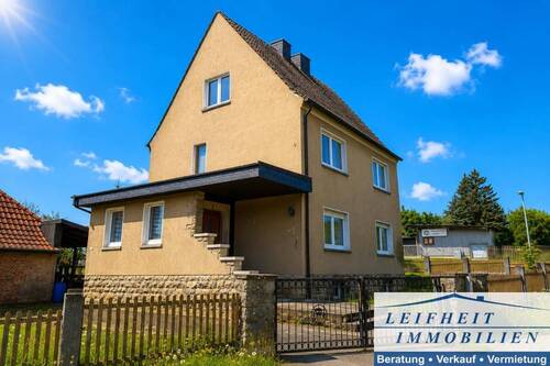 Vorder- und Seitenansicht - Solides Einfamilienhaus mit Garten und vielseitigem Entwicklungspotenzial