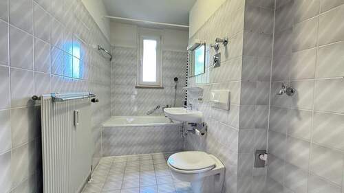 Badezimmer mit Fenster und Wanne - 