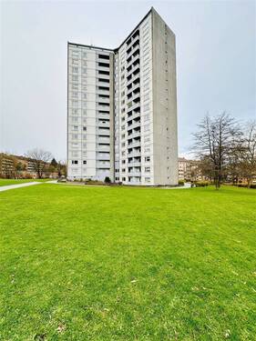 Hausansicht seitlich mit Grünflächen - Vermietete 2-Zimmer-Wohnung mit EBK, Balkon, Aufzug und Bodenkammer Kiel-Dietrichsdorf