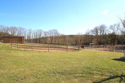 Der offene Longierzirkel und rechts der Reitplatz - 