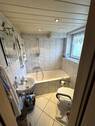 Bad im Erdgeschoss mit Badewanne, Fenster und WC - 