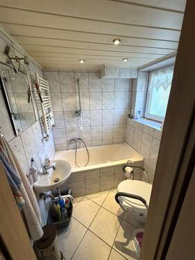 Bad im Erdgeschoss mit Badewanne, Fenster und WC - 