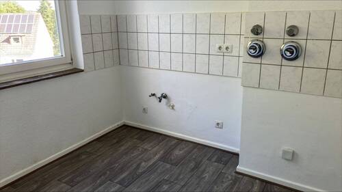 Ansicht Küche mit hellen Wänden und grauem Boden in Holzoptik - 