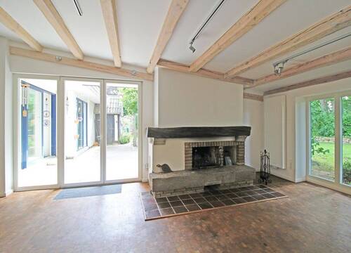 Wohnzimmer mit Zugang zur Terrasse und Kamin - 