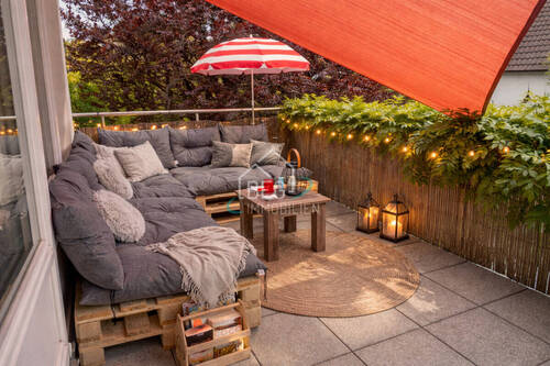 Gemütlicher Balkon mit Lichtern und Kissen - 