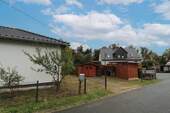 Blick auf die PKW-Stellplätze und die Gartenhäuschen - 