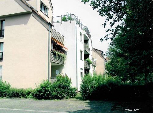 Theodor-Heuss-Allee 17 - 21, Außenansicht über den begrünten Innenhof auf die farbig abgesetzten Balkone mehrerer Wohngebäude mit Satteldach und Dachgauben - 3 Zimmer Etagenwohnung zur Miete in Baunatal