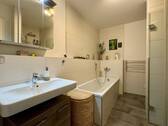 Bad mit Blick auf Waschbecken und Badewanne - 