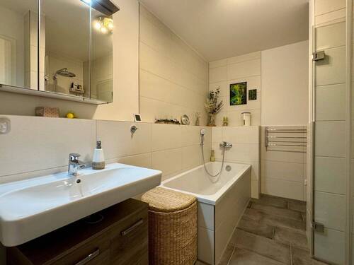 Bad mit Blick auf Waschbecken und Badewanne - 