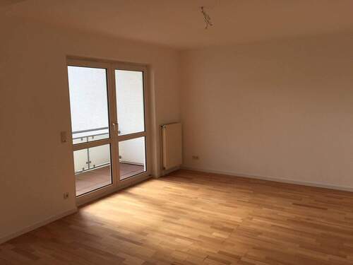 Wohnbereich mit Zugang auf den überdachten Balkon - 