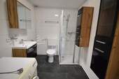 Badezimmer mit Dusche und Waschmaschinenanschluss - 